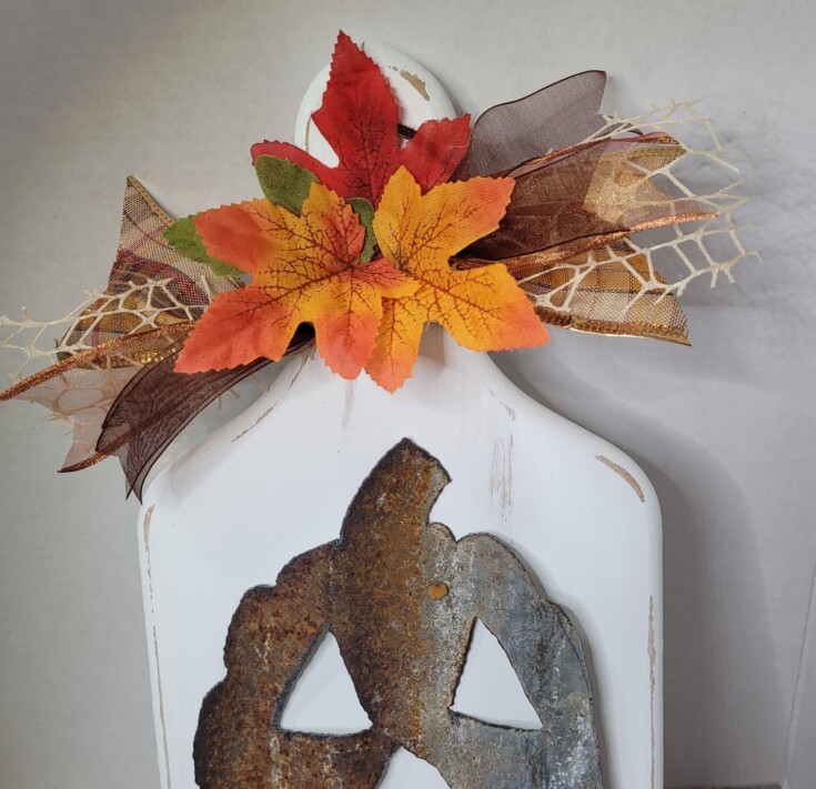 Attach ribbons and leaves to Halloween decor